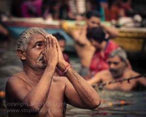 A man pays obeisance to the sun while bathing in the holy river, Varanasi - India