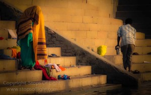 A woman changing after taking a dip in the holy river ganges at Varanasi, India